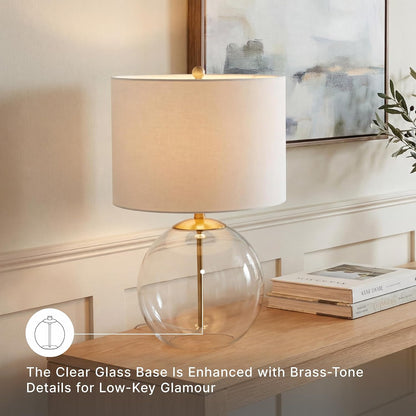 Signature Design by Ashley Glass Table Lamp, Modern Bedside, Clear & Brass | White Fabric Drum Shade, Compact round Clear Glass Profile for Modern Nightstands, Samder Series4