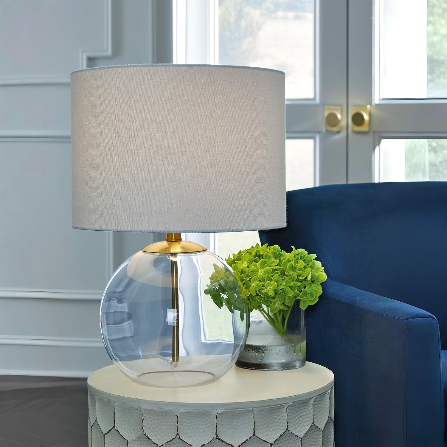 signature-design-by-ashley-glass-table-lamp-modern-bedside-clear-brass-white-fabric-drum-shade-compact-round-clear-glass-profile-for-modern-nightstands-samder-series